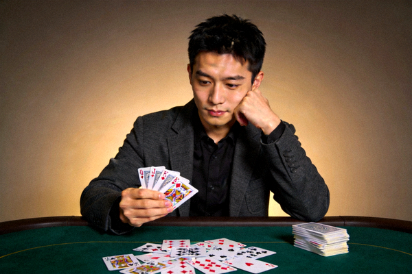 棋牌专家赵明远肖像照，年轻男性在牌桌前分析斗地主牌型，展现专业牌手素养